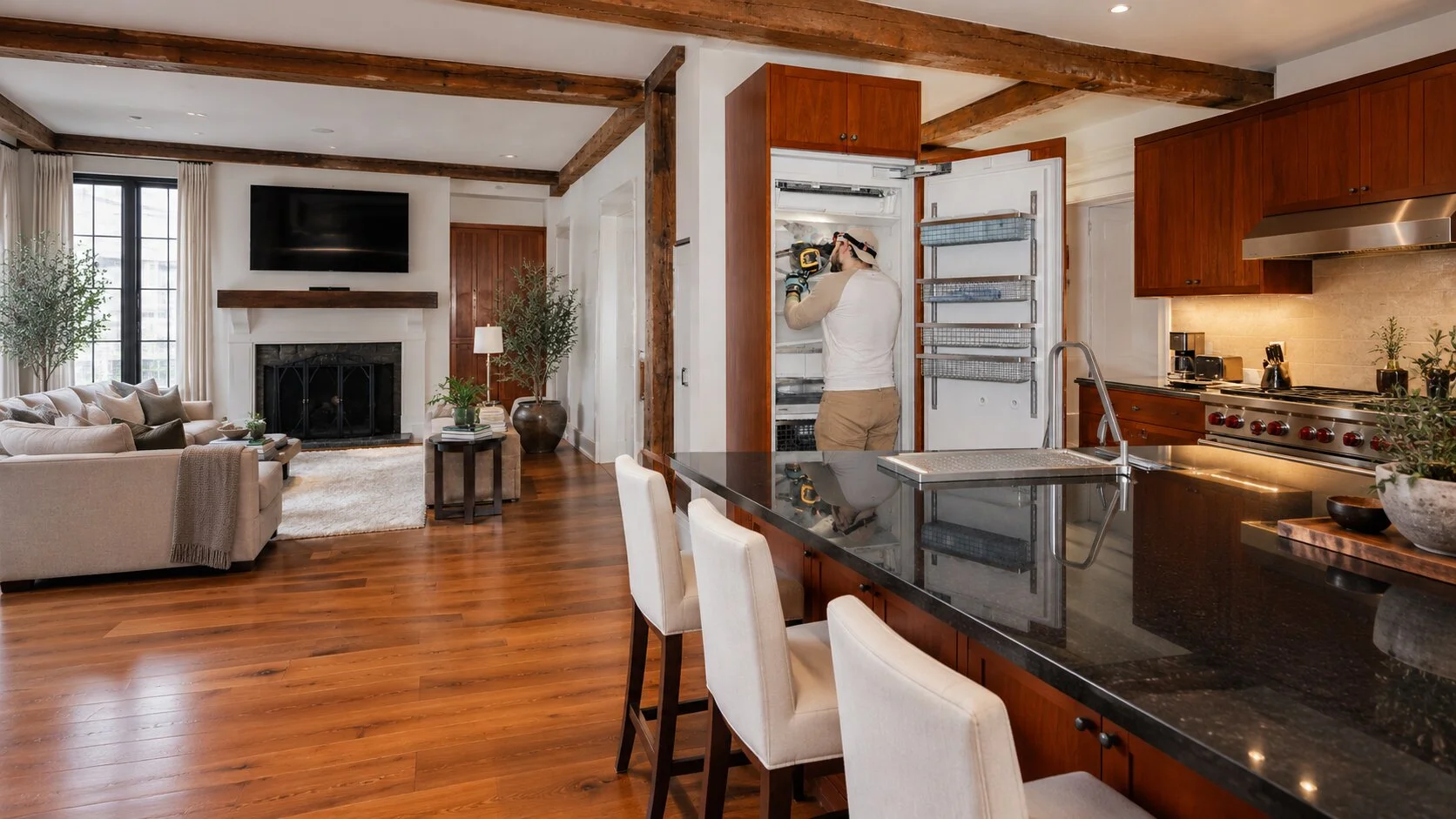 A technician carefully working on a built-in Sub-Zero refrigerator in a beautifully appointed Manhattan-style home