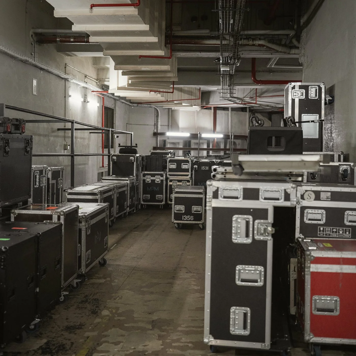 Flight cases con equipo de audio e iluminación listos para el montaje de un evento