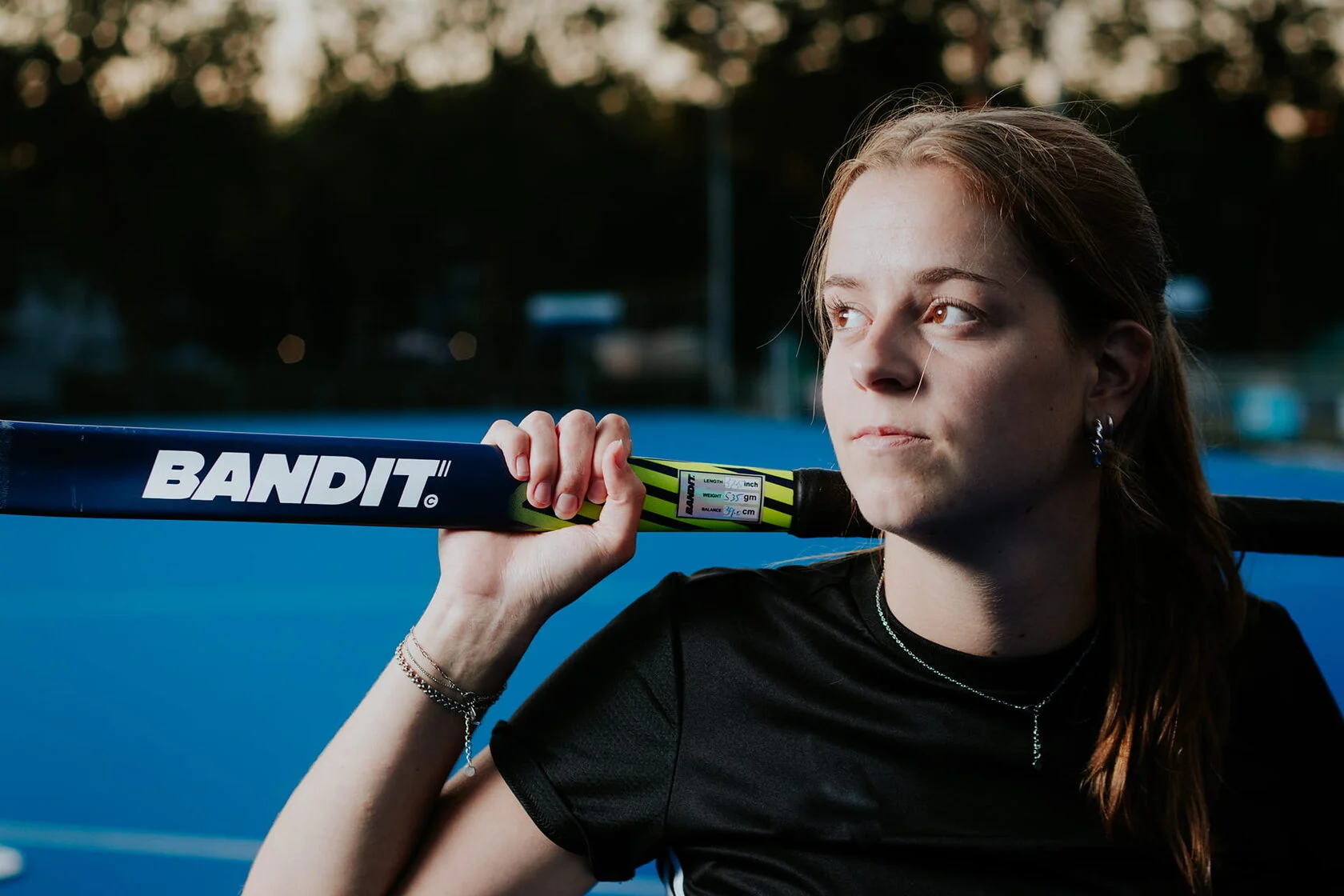 Hockeyster met een blauw-gele Bandit hockeystick op een blauw hockeyveld.