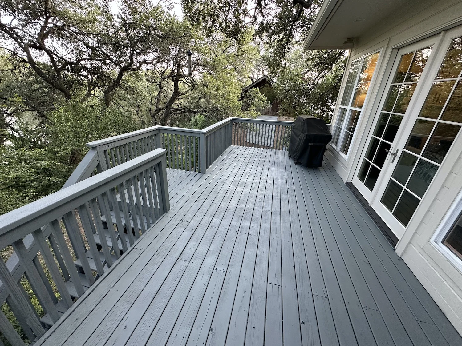 Deck after restoration in Austin TX — new post, sanded surface and two-coat UV-resistant gray paint