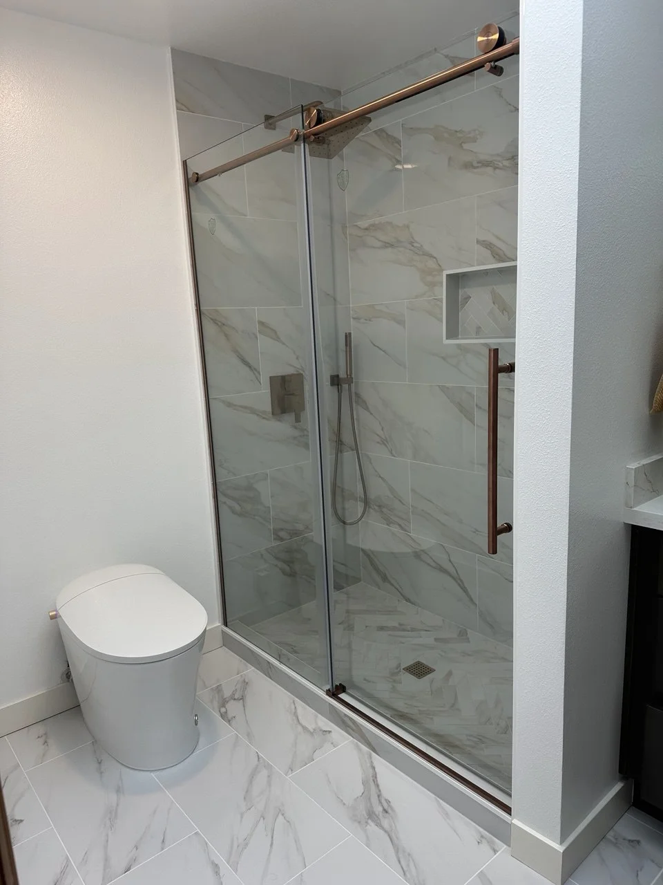 Frameless glass walk-in shower with gold hardware