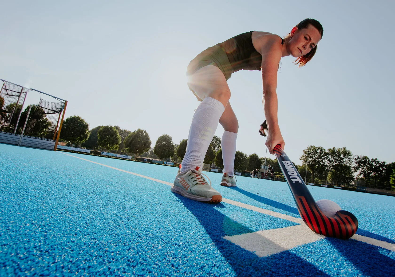 Vrouwelijke speler in actie met een rood-zwarte Bandit hockeystick.