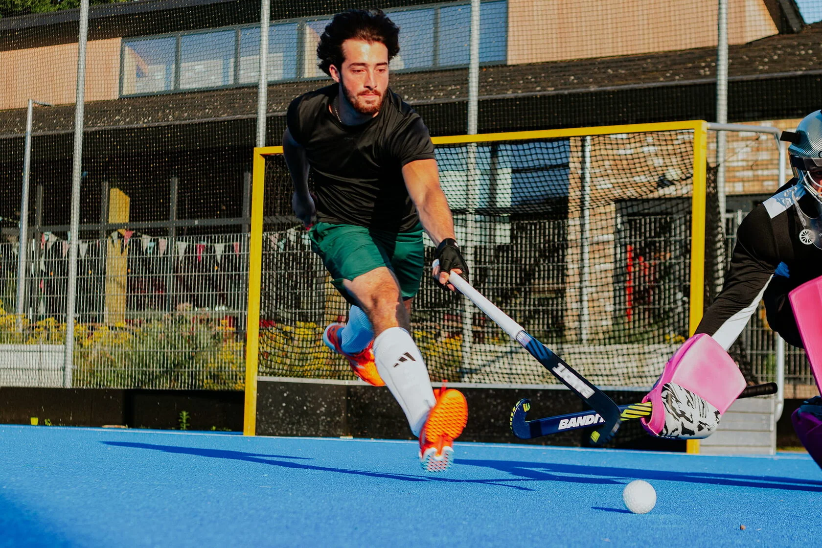 Aanvallende speler in actie met een wit-blauwe Bandit hockeystick.