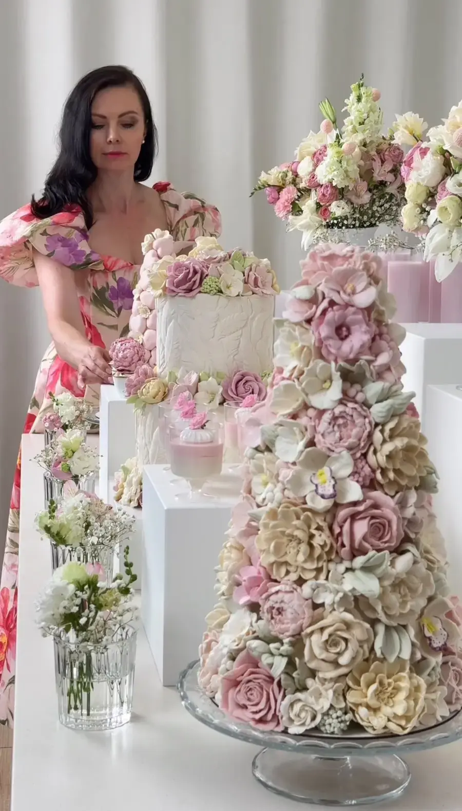 Natalia beside a dessert table with a tall tower of handmade zefir flowers in soft pink and cream