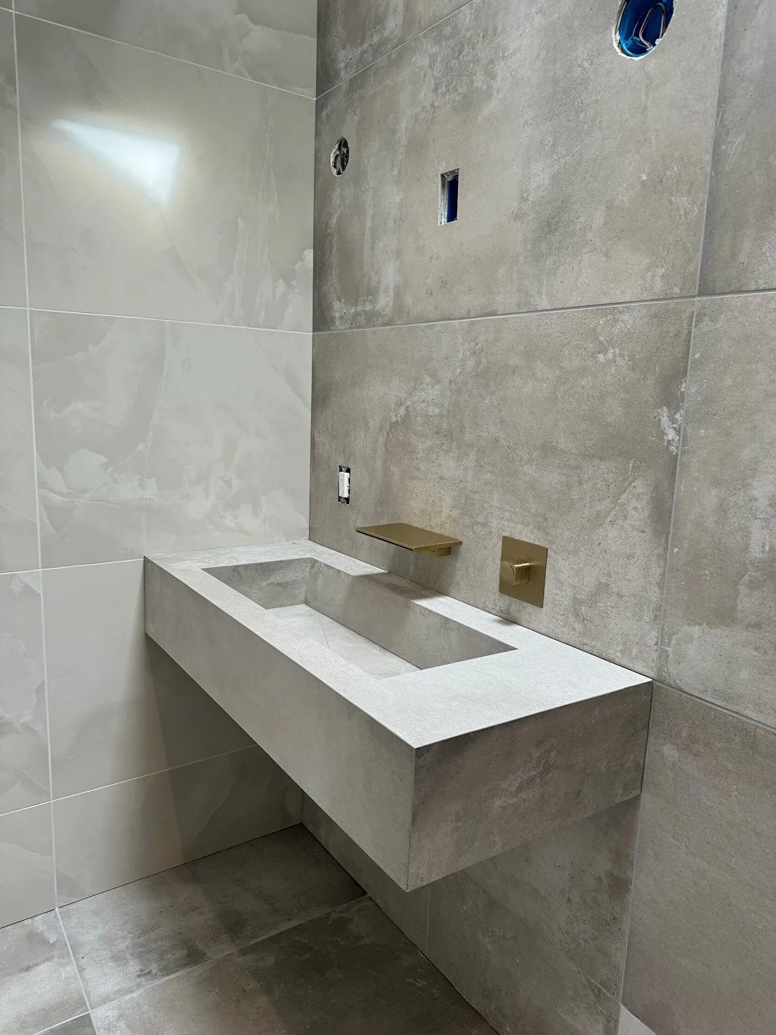 Floating concrete vanity with wall-mounted faucet