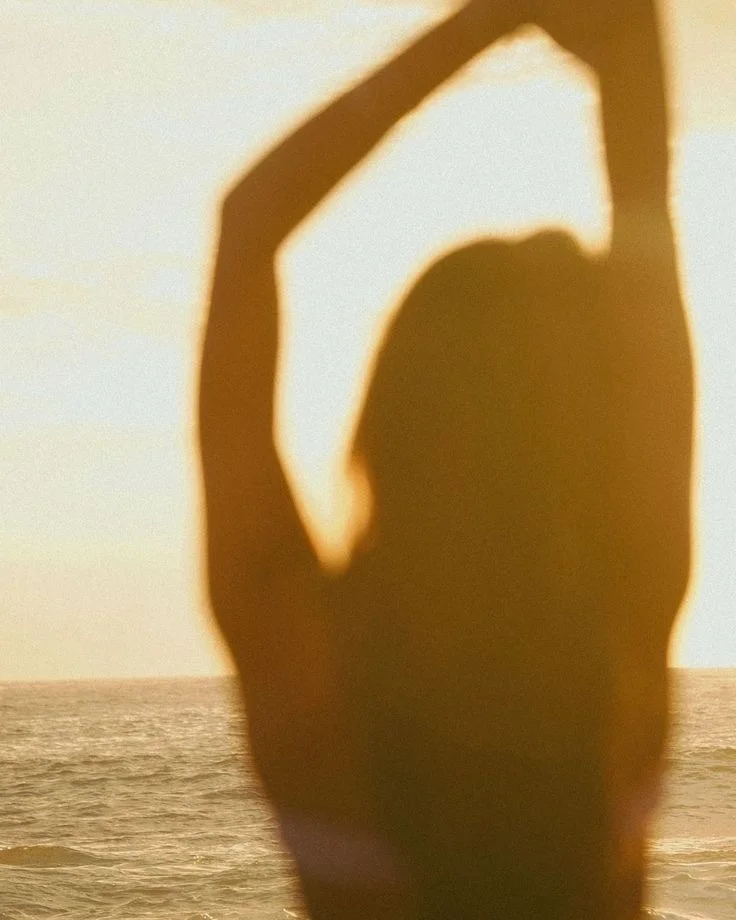 Silhouette of a woman at sunset by the sea