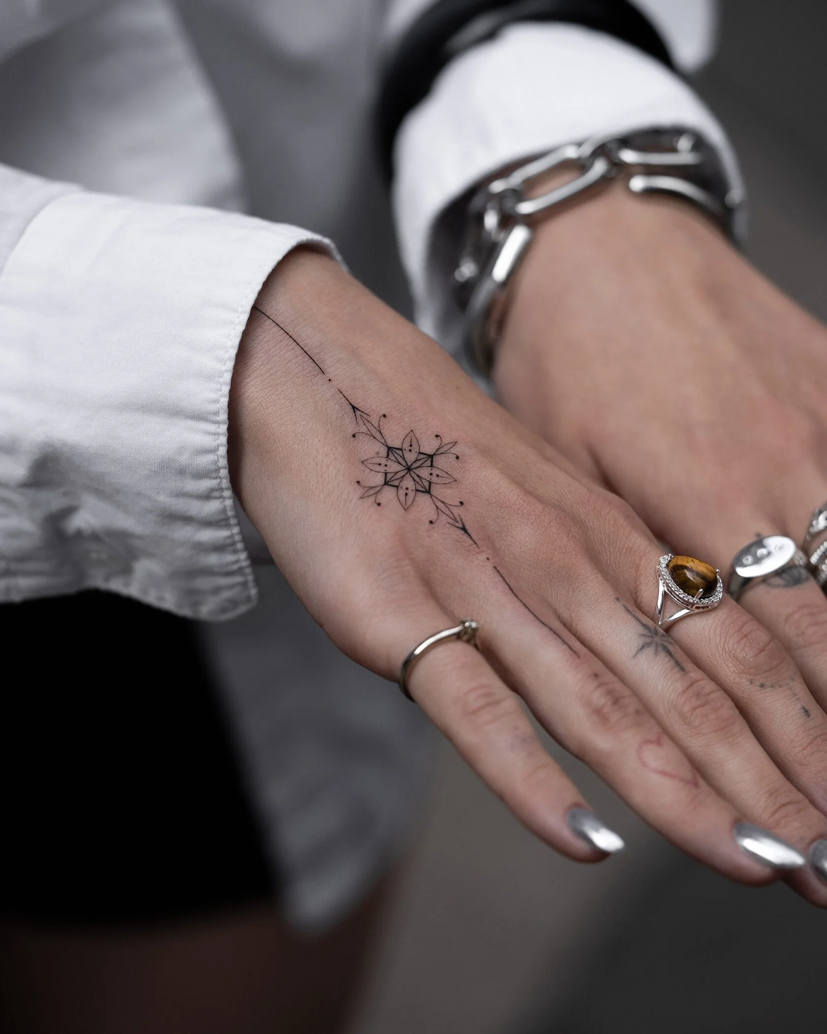 Feines florales Ornamental Tattoo auf dem Handrücken