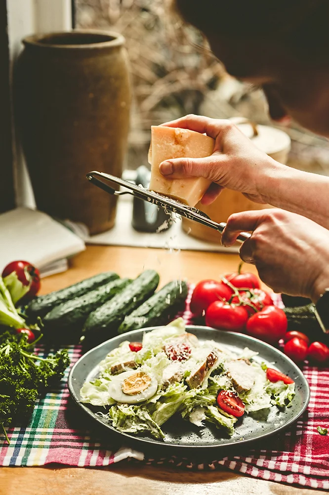 A dish being finished by hand in a working kitchen
