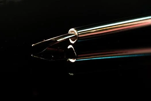 Close-up of a pen on black — one wrong word in the copy ends a restricted account