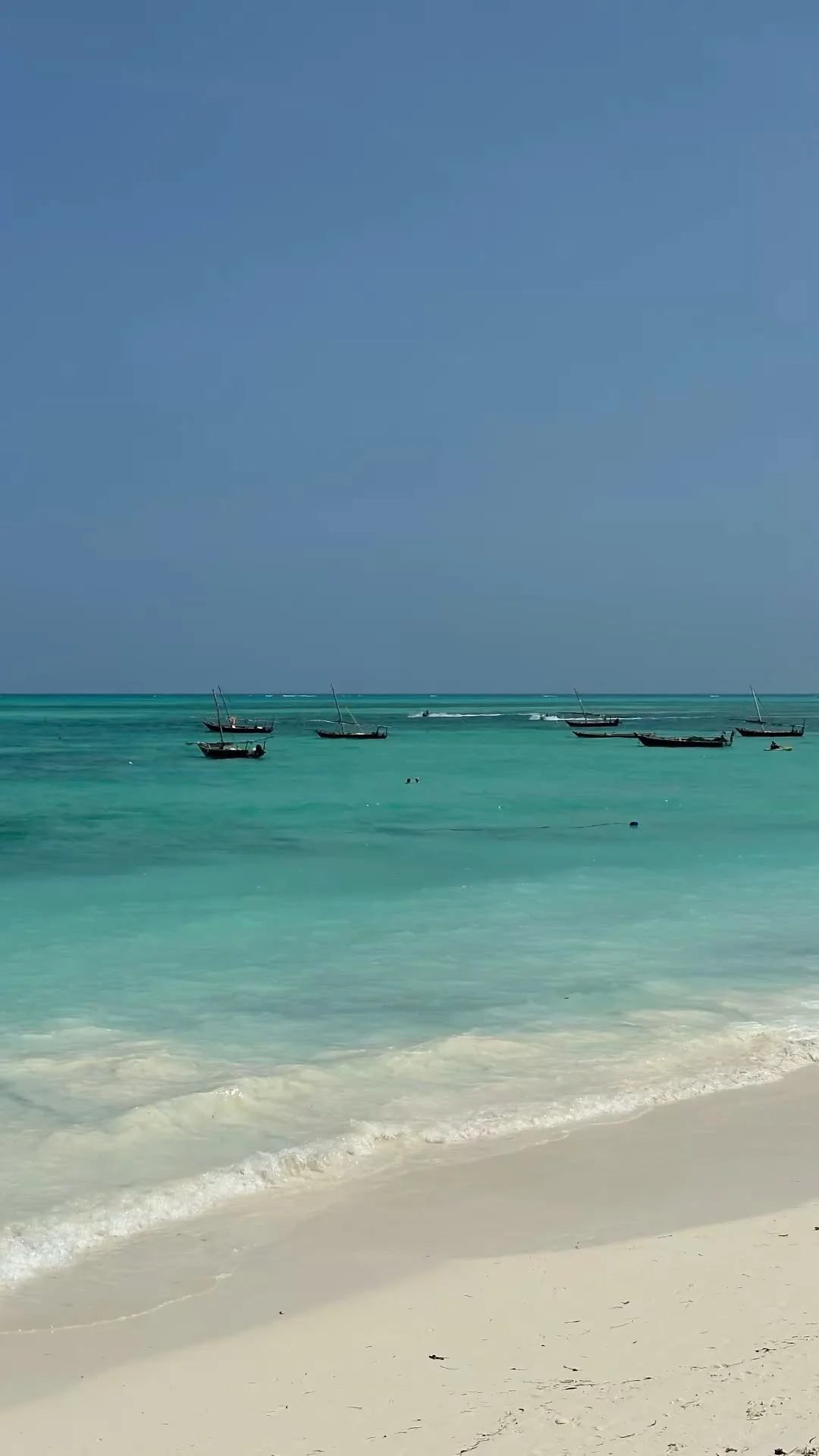 Turquoise water, white sand and traditional dhows in Zanzibar