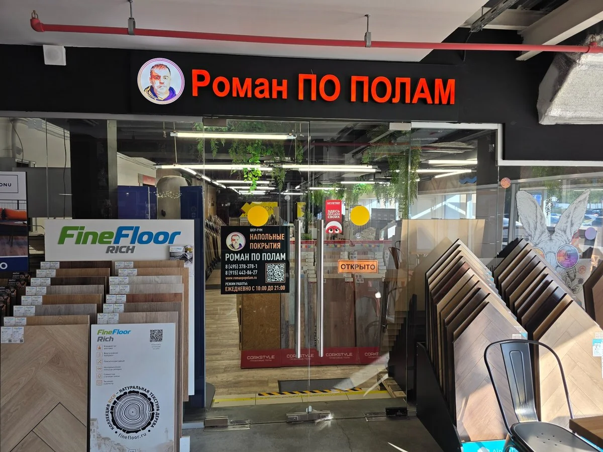 Вход в магазин Роман по полам с красной вывеской в торговом центре