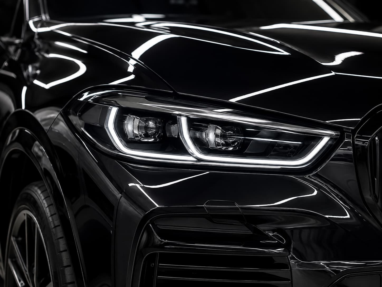 Glossy black vehicle close-up representing detailing and ceramic coating