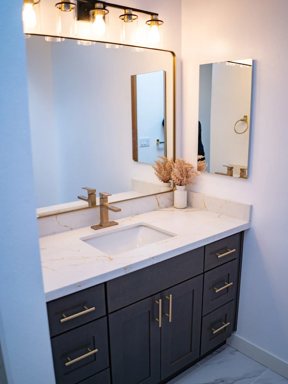 Navy vanity with brass faucet and white counter