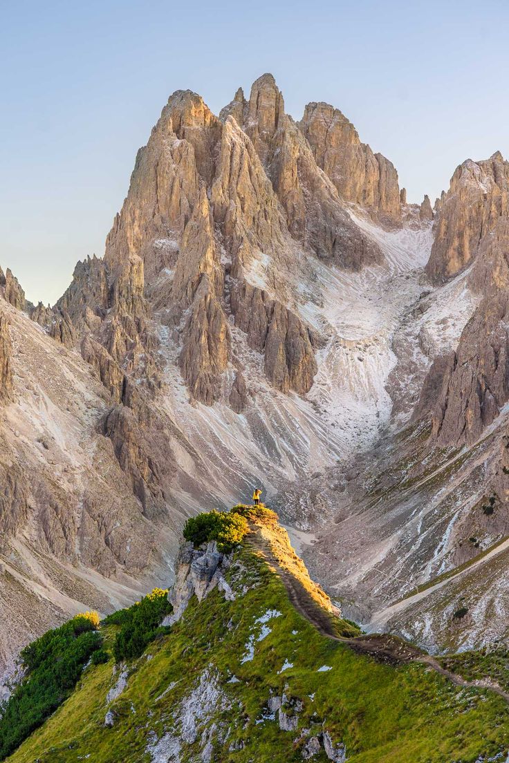 A walker on a trail among the peaks of the Dolomites