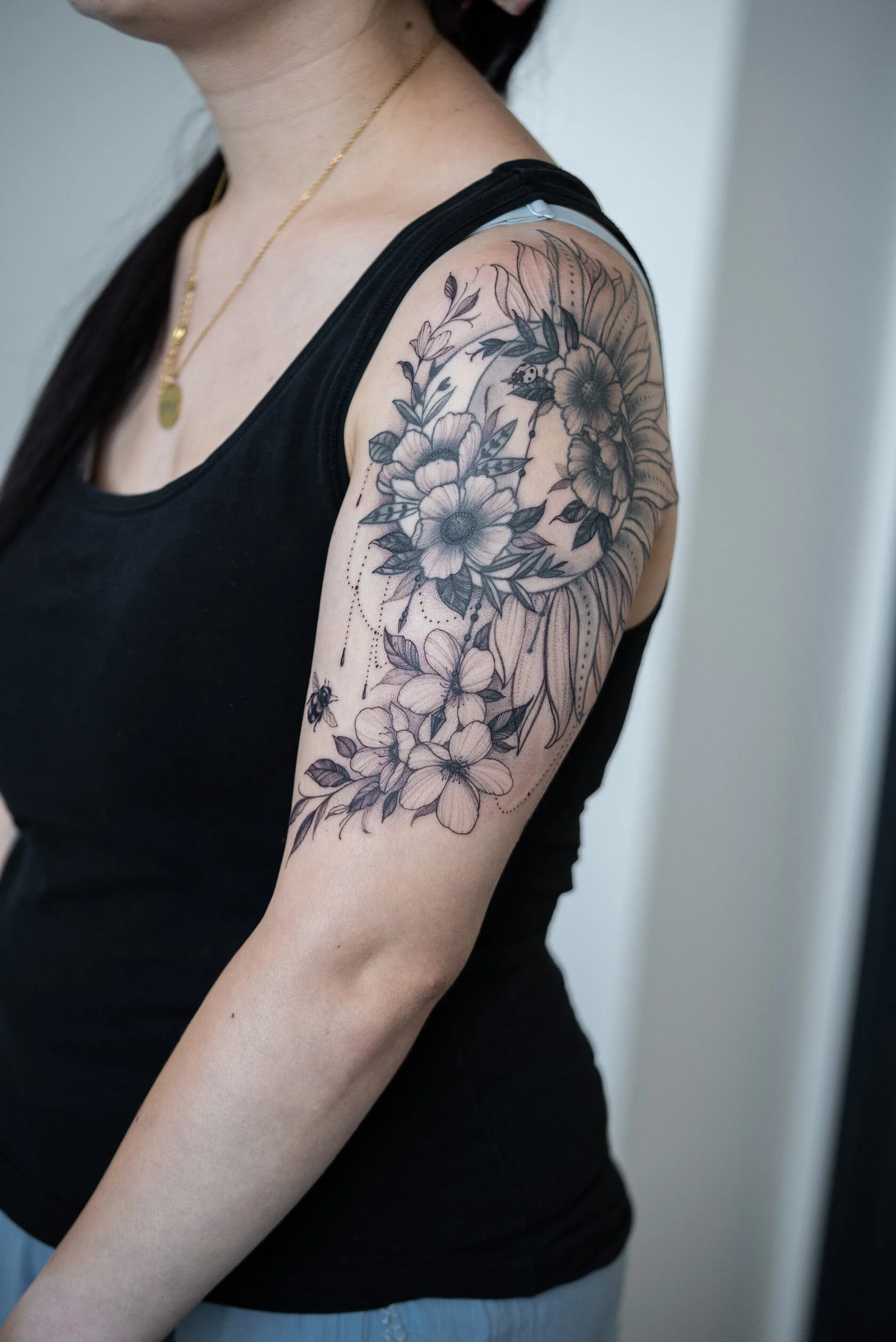 Verheiltes Sonne-Mond-Blumen-Tattoo am Oberarm