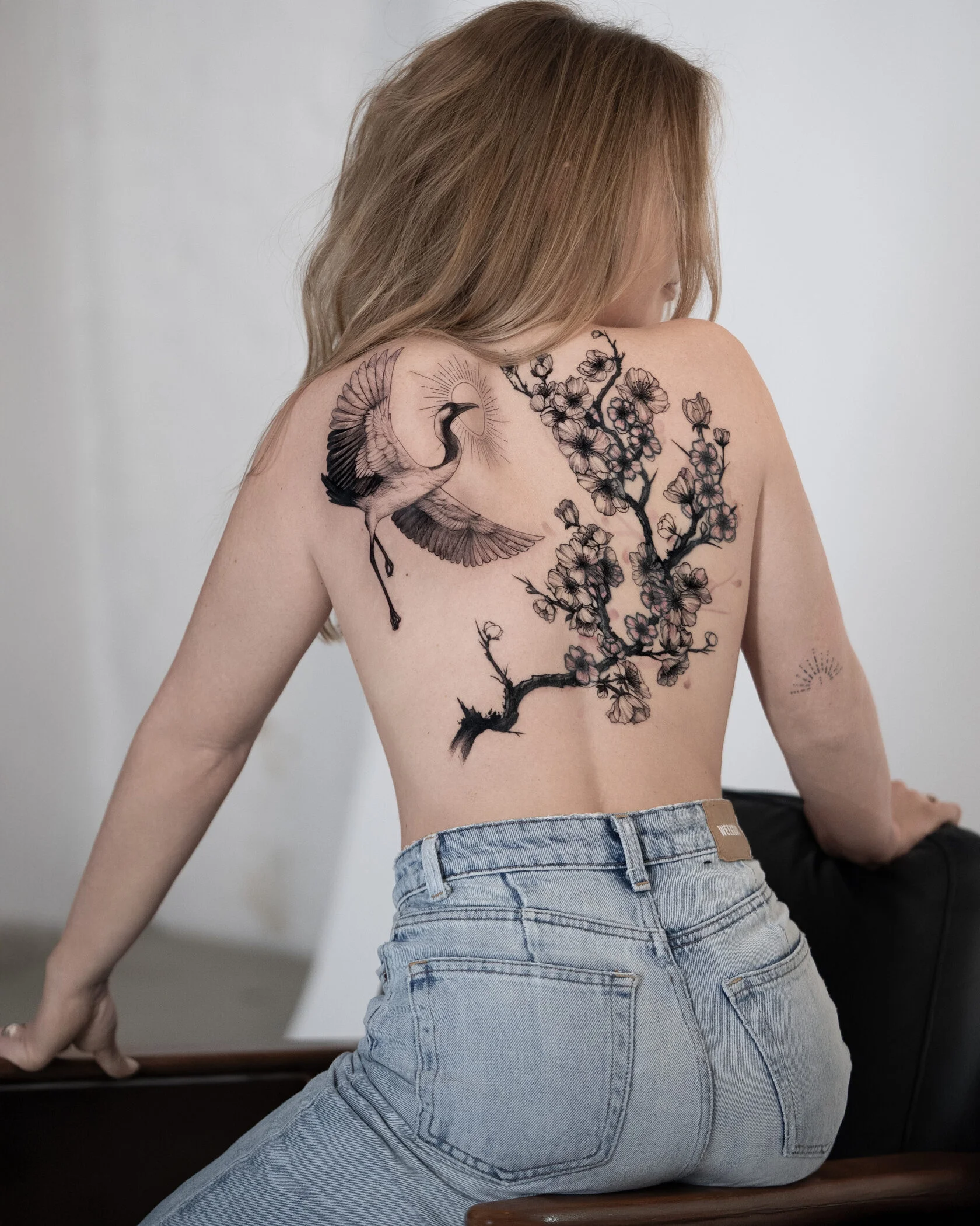 Cover-Up Tattoo mit Kranich und Kirschblütenzweig am Rücken