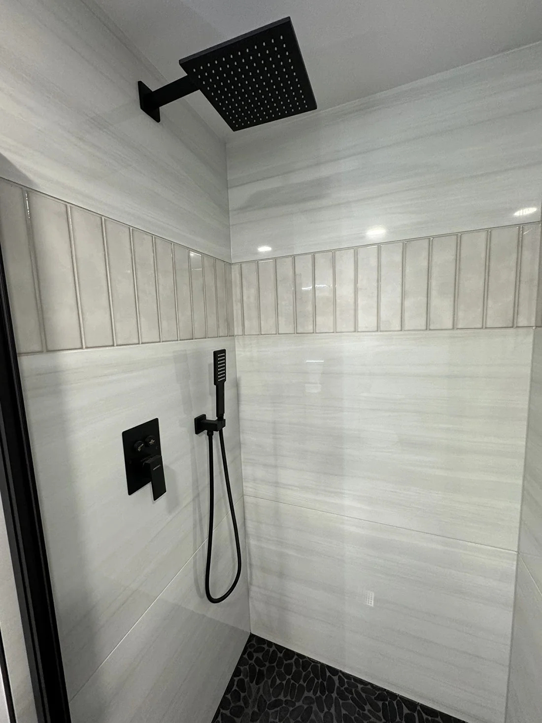 Striped-marble walk-in shower with black fixtures